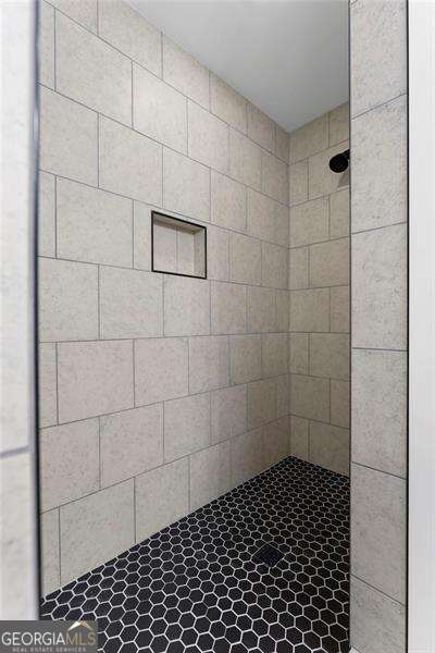 full bath featuring a tile shower