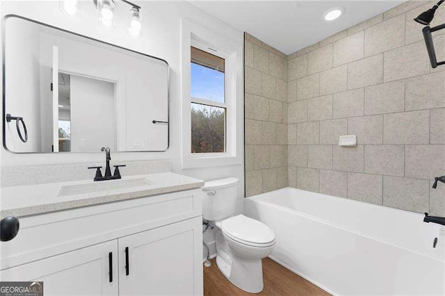 full bathroom with toilet, wood finished floors, and vanity