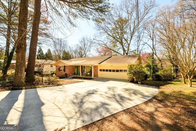 ranch-style home with a garage, brick siding, and concrete driveway