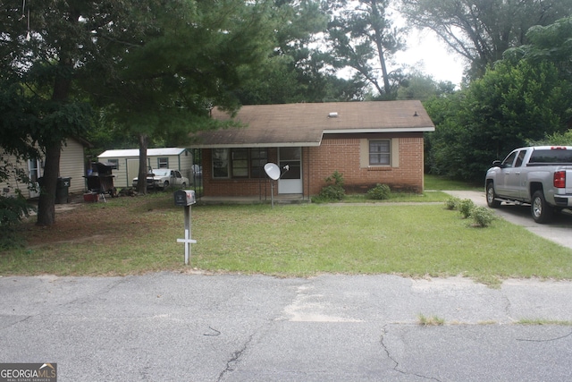 view of front of home featuring a front lawn and brick siding