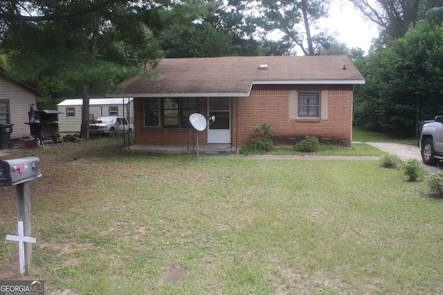 view of front of property featuring brick siding and a front yard