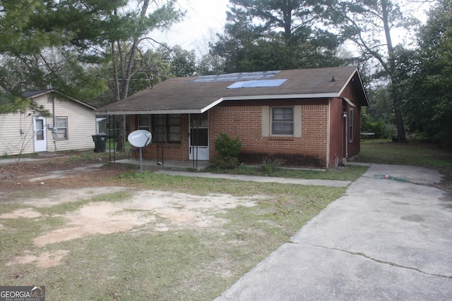 view of front of property featuring brick siding and solar panels