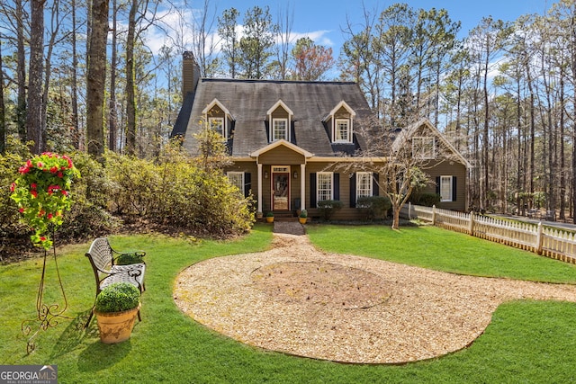 cape cod home with a chimney, a front yard, and fence