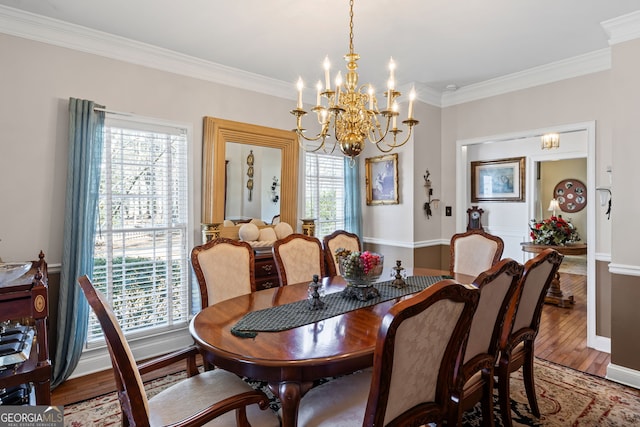 dining area featuring a notable chandelier, ornamental molding, baseboards, and wood finished floors