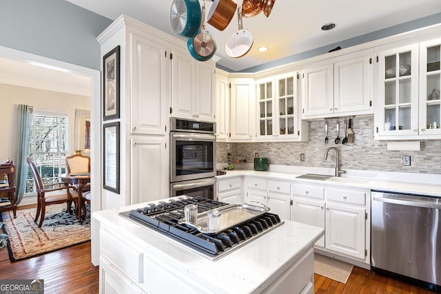 kitchen with a sink, dark wood finished floors, backsplash, and stainless steel appliances