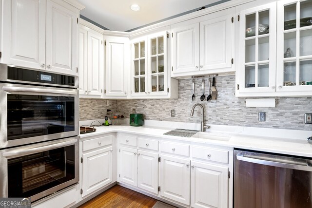 kitchen with a sink, appliances with stainless steel finishes, and white cabinets