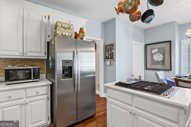 kitchen featuring tasteful backsplash, white cabinets, appliances with stainless steel finishes, and light countertops