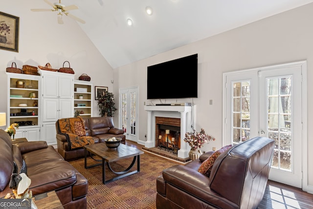 living room featuring a wealth of natural light, french doors, wood finished floors, and a fireplace