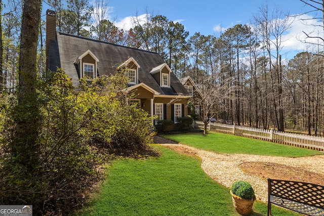 view of front of house with a front yard and fence