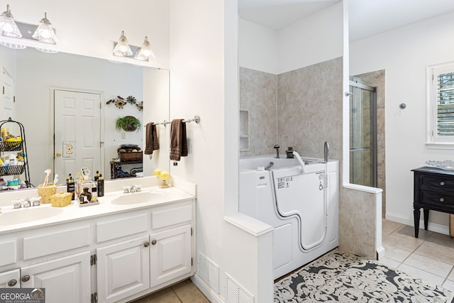 bathroom with double vanity, tile patterned flooring, a stall shower, and a sink