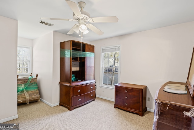 bedroom featuring visible vents, baseboards, light colored carpet, and a ceiling fan