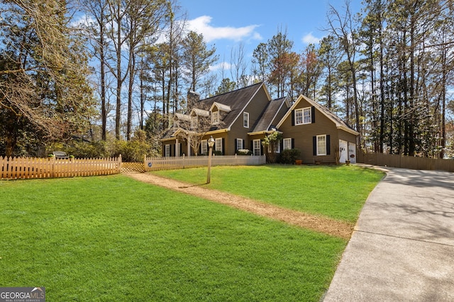 view of front facade featuring a front lawn, a garage, a fenced front yard, and a chimney