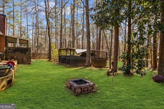 view of yard featuring a wooden deck and a fire pit