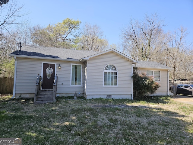 ranch-style house with a front lawn, fence, entry steps, roof with shingles, and crawl space