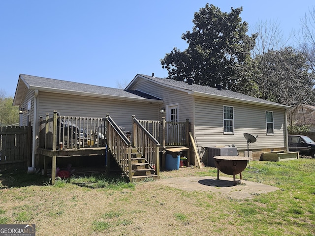 rear view of house with a lawn, cooling unit, and a deck