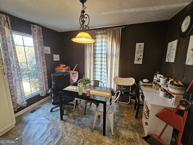 dining room with visible vents, baseboards, and a textured ceiling