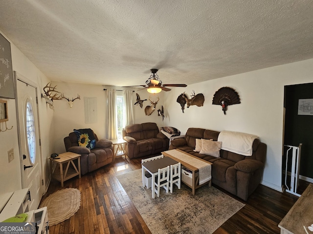 living room featuring dark wood-style floors, a textured ceiling, and ceiling fan