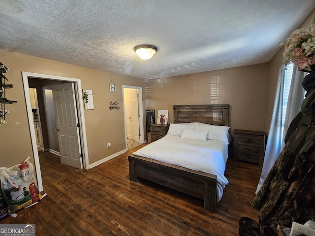 bedroom with wood finished floors, baseboards, and a textured ceiling