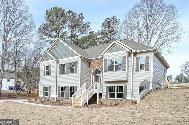 view of front of house featuring stone siding and roof with shingles