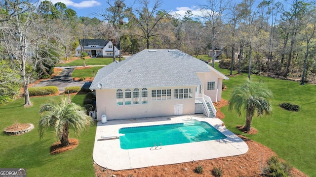 exterior space featuring a diving board, a yard, stairway, and a patio area