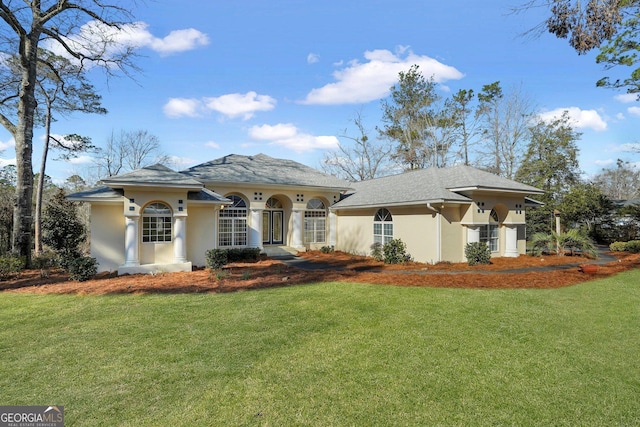 mediterranean / spanish home featuring a front lawn and stucco siding