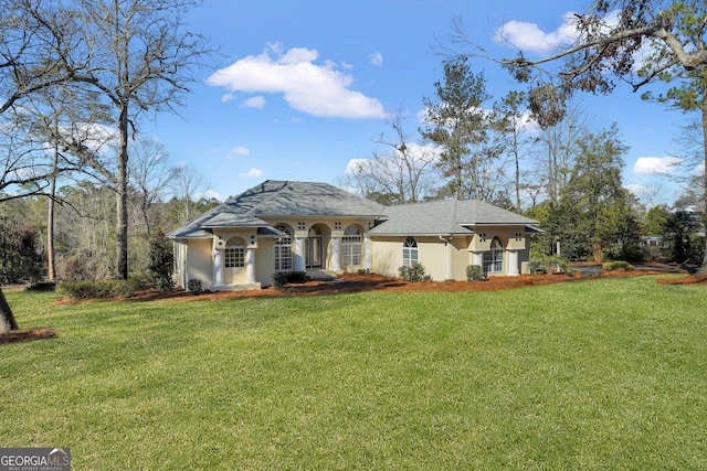 back of property with stucco siding and a yard