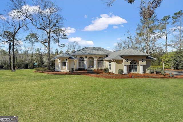 rear view of property featuring a lawn and stucco siding