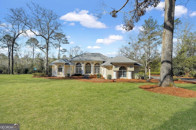 mediterranean / spanish house featuring stucco siding and a front yard