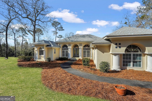 view of front facade featuring stucco siding and a front yard