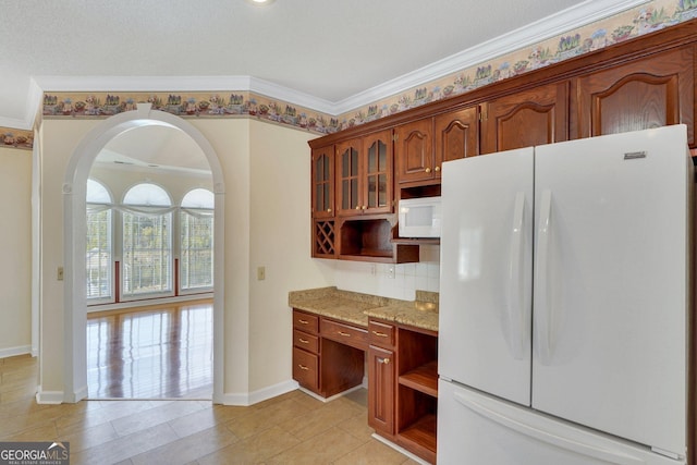 kitchen with white appliances, light stone counters, arched walkways, and open shelves