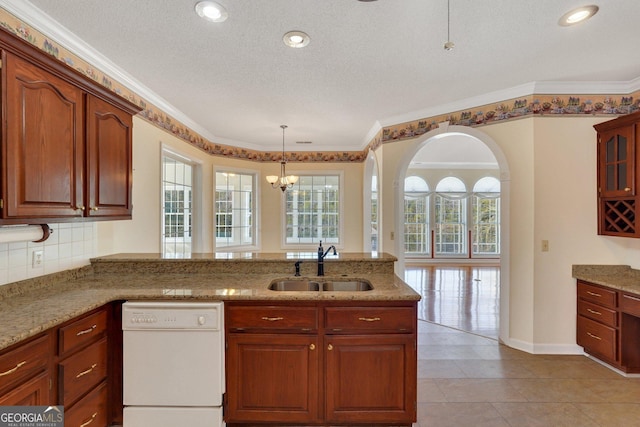 kitchen featuring a sink, light stone counters, backsplash, a peninsula, and dishwasher