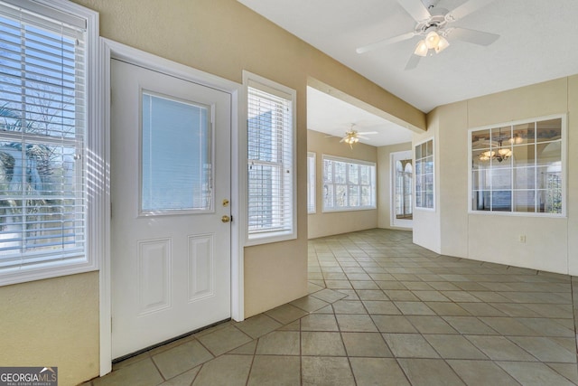 entrance foyer with ceiling fan and tile patterned flooring