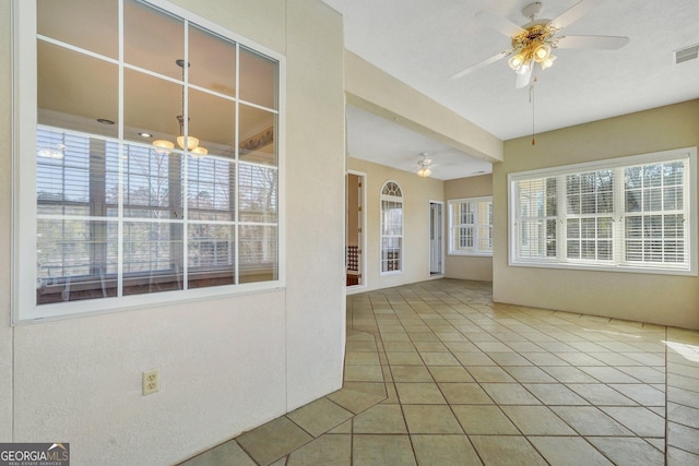 unfurnished sunroom with visible vents and ceiling fan with notable chandelier