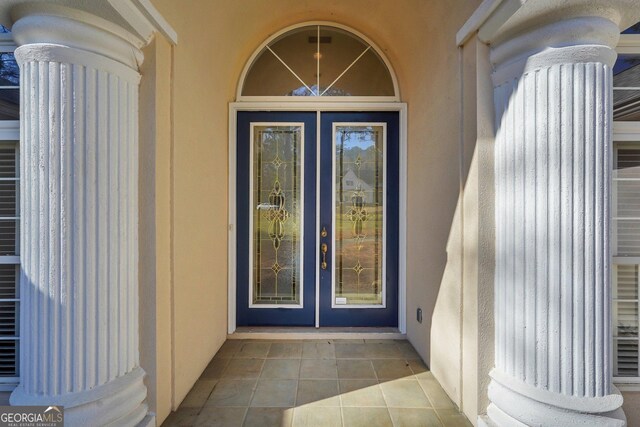 doorway to property featuring stucco siding