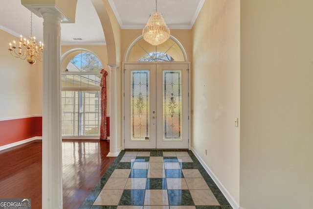 entryway featuring a notable chandelier, french doors, and crown molding