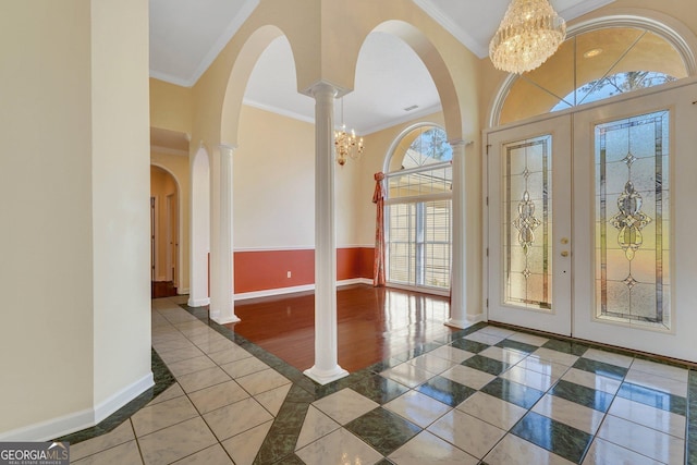 entrance foyer featuring a notable chandelier, baseboards, and ornamental molding