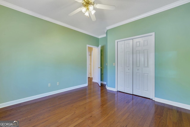 unfurnished bedroom with baseboards, ornamental molding, wood finished floors, a closet, and a ceiling fan