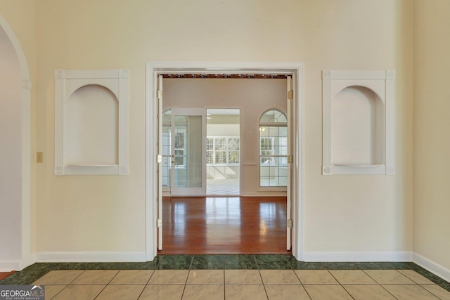 interior space with baseboards and tile patterned flooring