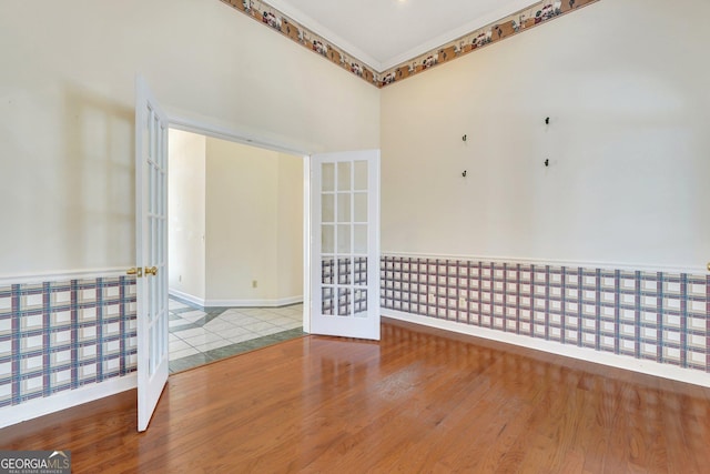 unfurnished room featuring wood finished floors and french doors