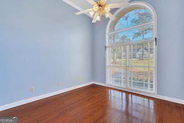 unfurnished room with ceiling fan, dark wood-type flooring, and baseboards