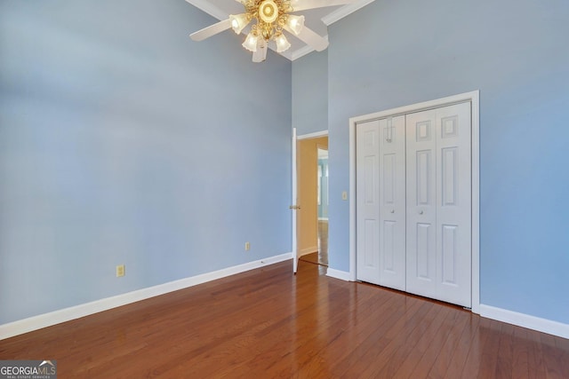 unfurnished bedroom with ceiling fan, a closet, baseboards, and wood finished floors