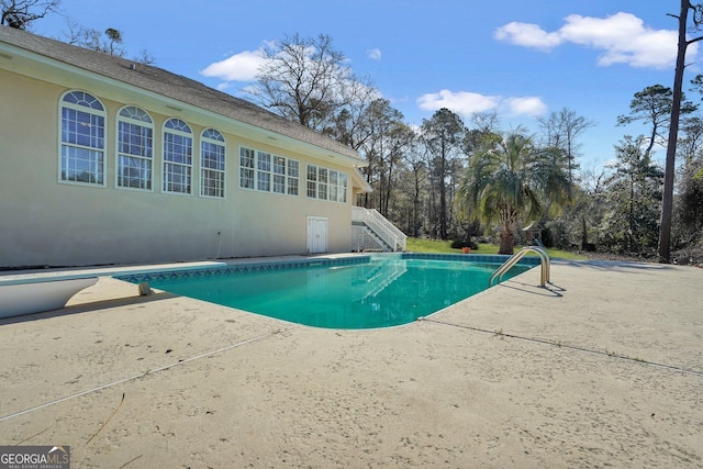 pool with a patio area and stairway