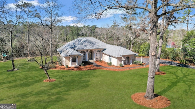 view of front of home featuring a front lawn and a forest view