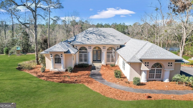 mediterranean / spanish house with stucco siding and a front yard