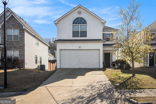 traditional home featuring central air condition unit, driveway, and a garage