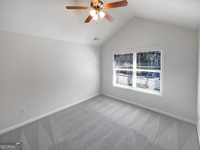 carpeted spare room with visible vents, lofted ceiling, baseboards, and a ceiling fan