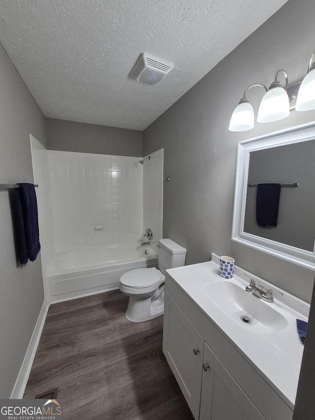 full bathroom with wood finished floors, visible vents, shower / washtub combination, a textured ceiling, and toilet