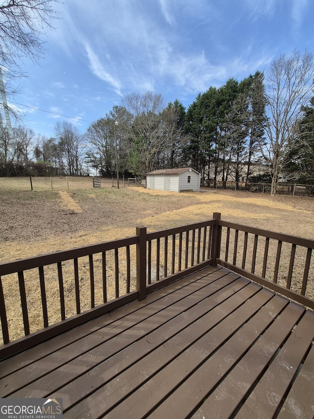 deck featuring an outdoor structure and fence