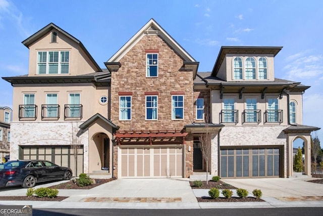 view of property featuring a balcony, a garage, and driveway