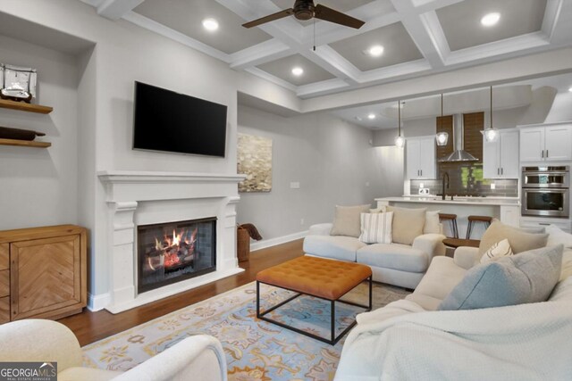202 Via Lucca, Woodstock, GA 30188 - living area featuring wood finished floors, coffered ceiling, beam ceiling, and a glass covered fireplace